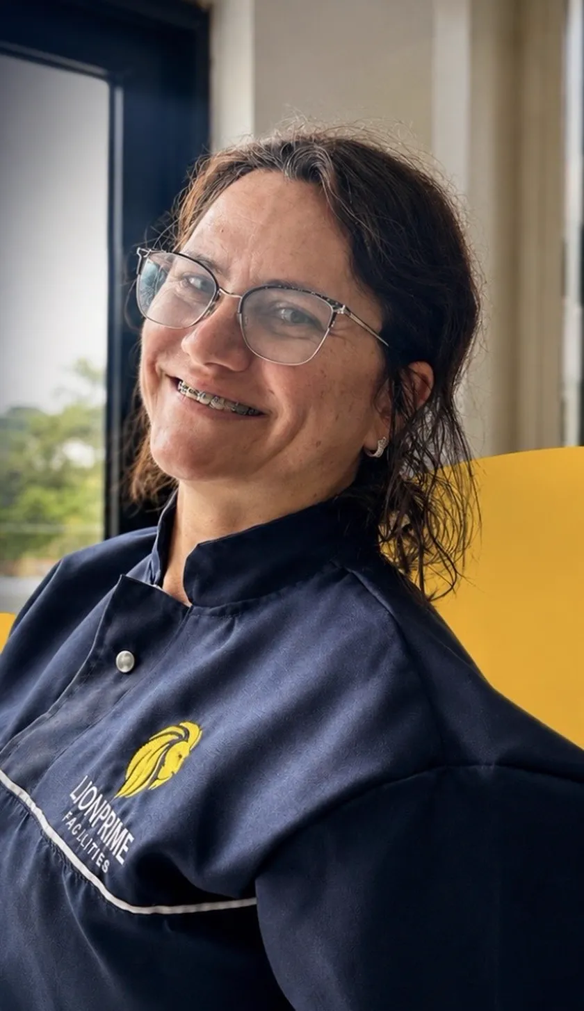 Colaboradora LionPrime uniformizada sorrindo